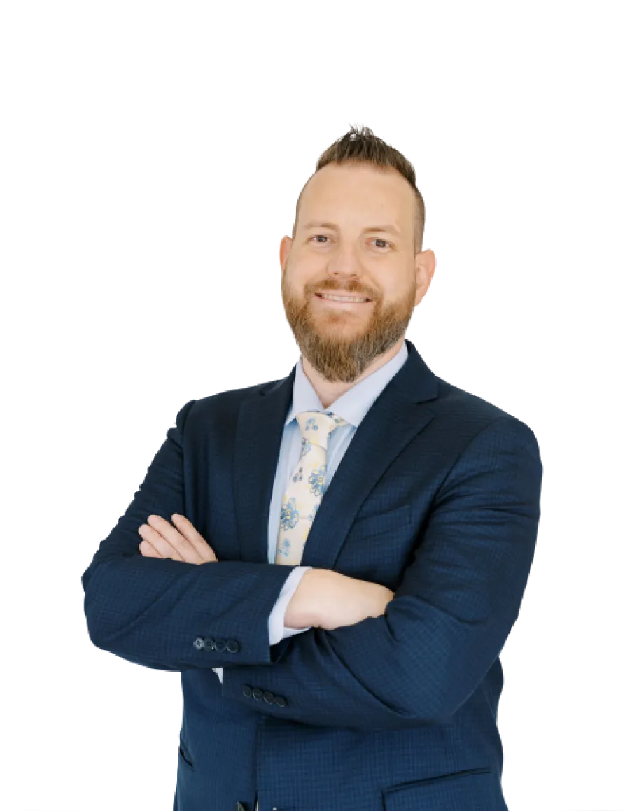 Smiling bearded man in navy suit and floral tie with arms crossed facing camera, isolated on white background