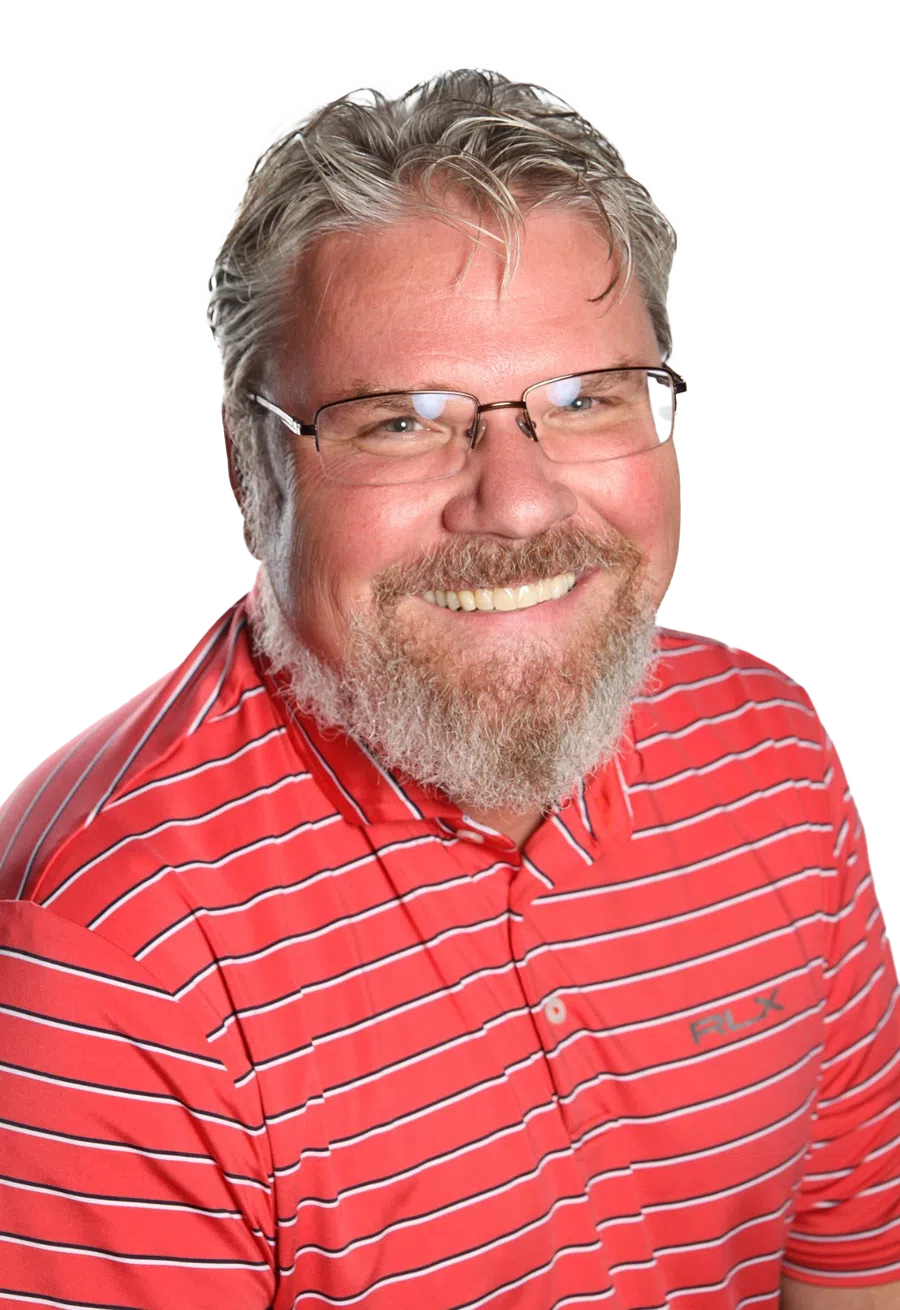 Smiling middle-aged man with glasses and a beard wearing a red striped RLX polo shirt.