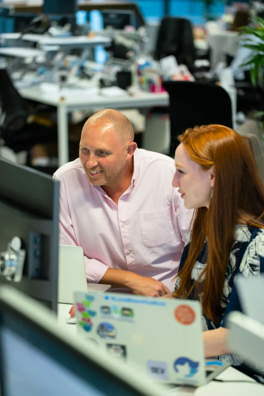 a man and woman looking at a laptop