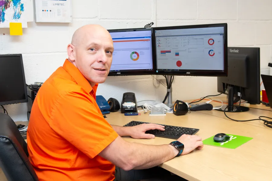 a man sitting at a desk with a computer and other monitors