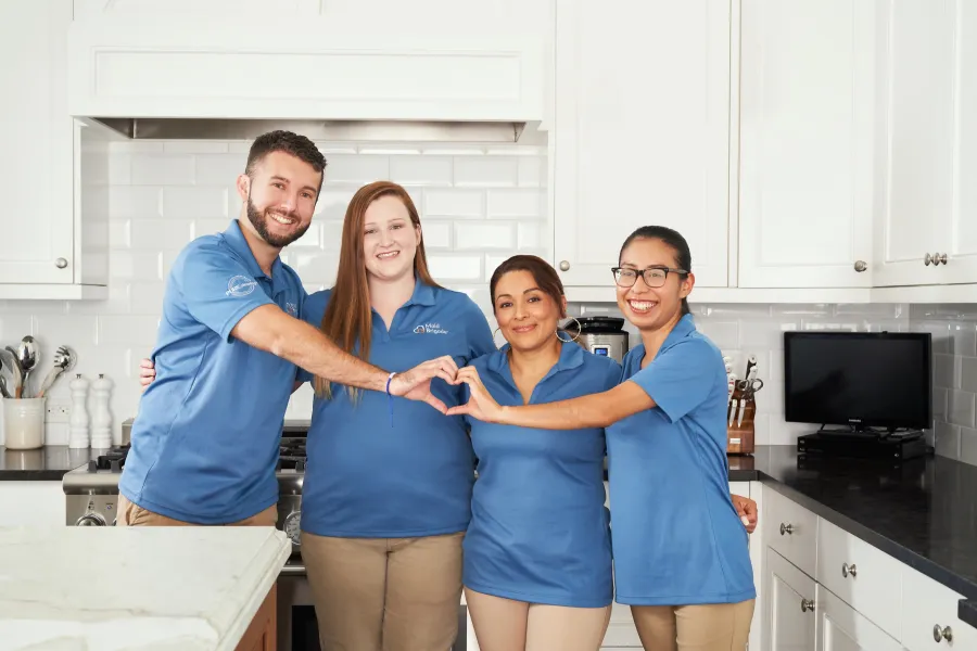 a group of people posing for a photo in a kitchen