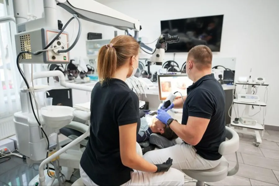 Dentists examining a patient using digital dental equipment in a modern dental clinic with advanced technology.