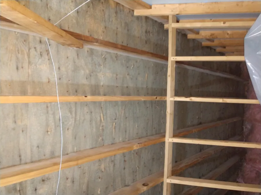 Wooden framing and insulation installed on an attic ceiling for home construction or renovation.