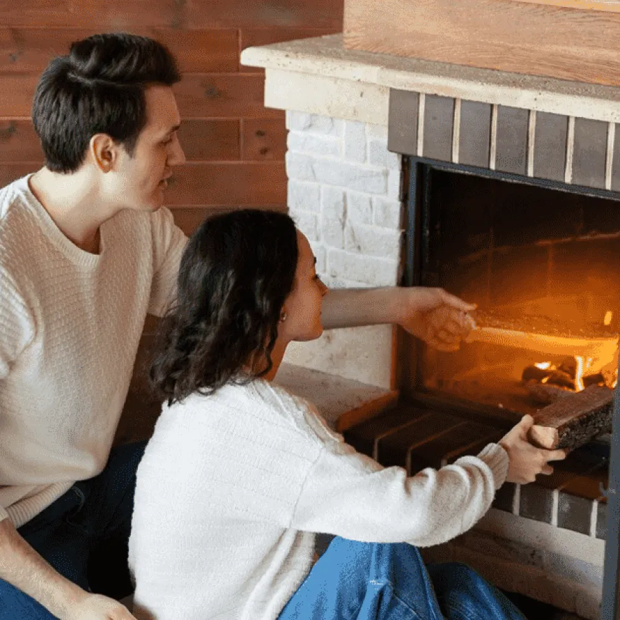 a man and a woman sitting by a fireplace