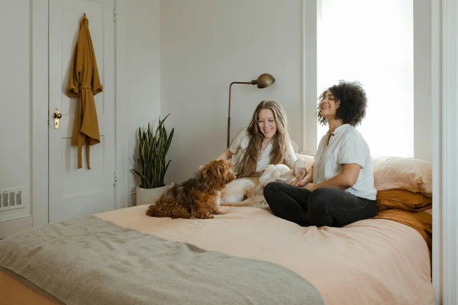 a person and a dog sitting on a bed