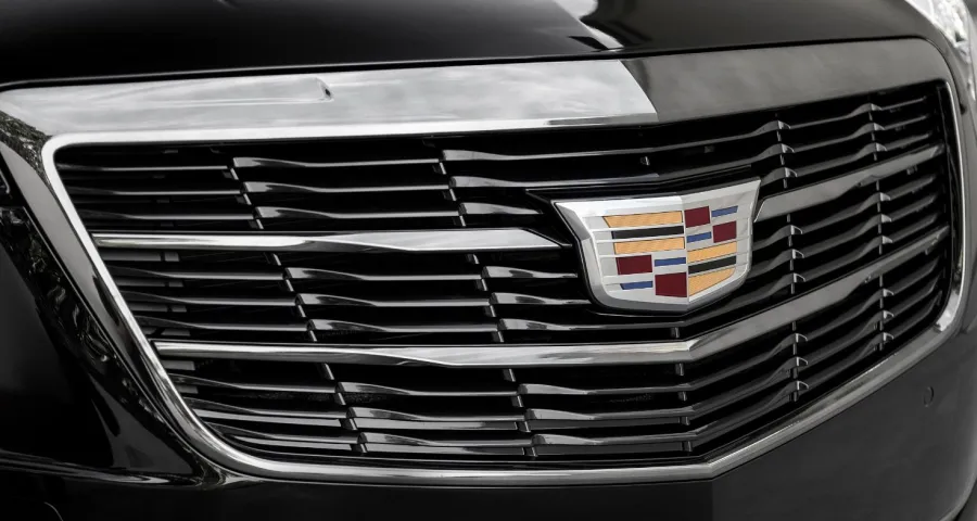 Close-up of a Cadillac grille with sleek chrome accents and the iconic logo prominently displayed.