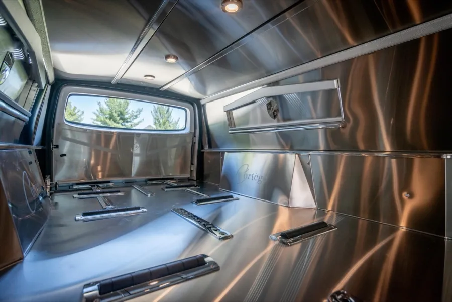 Interior of a stainless steel truck bed showcasing sleek design and functional layout.