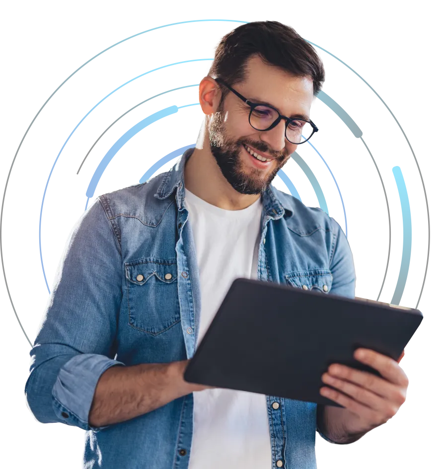 Smiling man in glasses and denim shirt using a digital tablet with futuristic blue circular graphics behind him