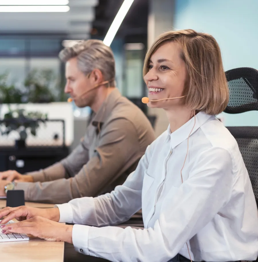 a woman and a man sitting at a table looking at a computer