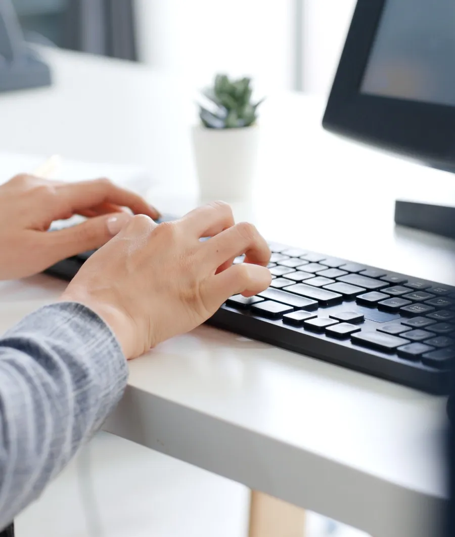 a close-up of hands typing on a keyboard