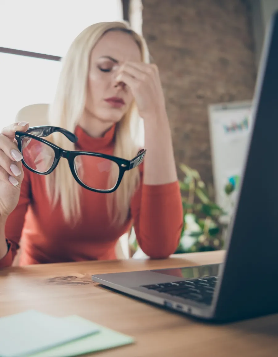 a person sitting at a desk with the hands on the face