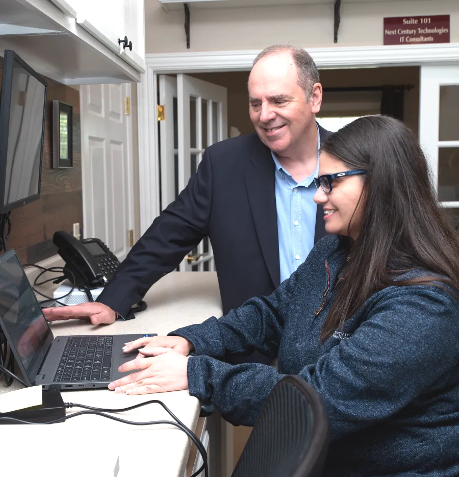 a man and a woman looking at a laptop