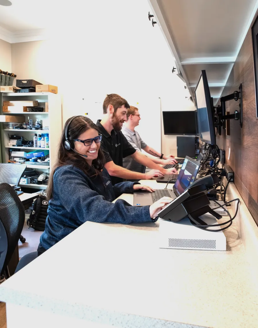 a group of people sitting at a table with computers