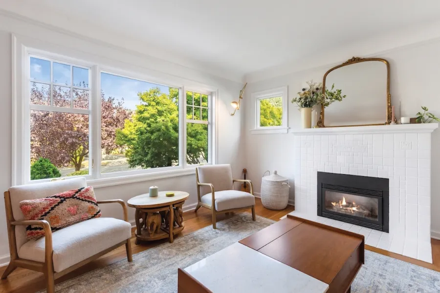 a living room with a fireplace and large double paned windows with sound reduction