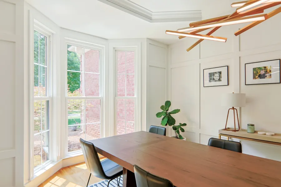 a dining room table with chairs and a plant on it