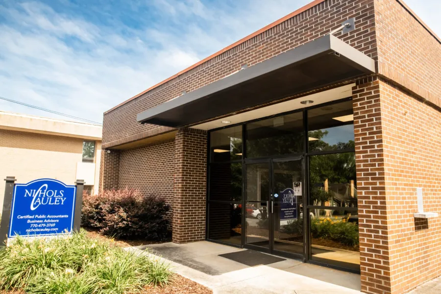 Brick office building of Nichols Cauley Certified Public Accountants with blue sign and glass entrance door