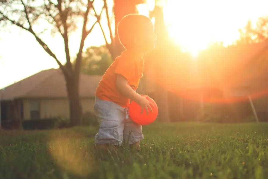 a toddler holding a ball