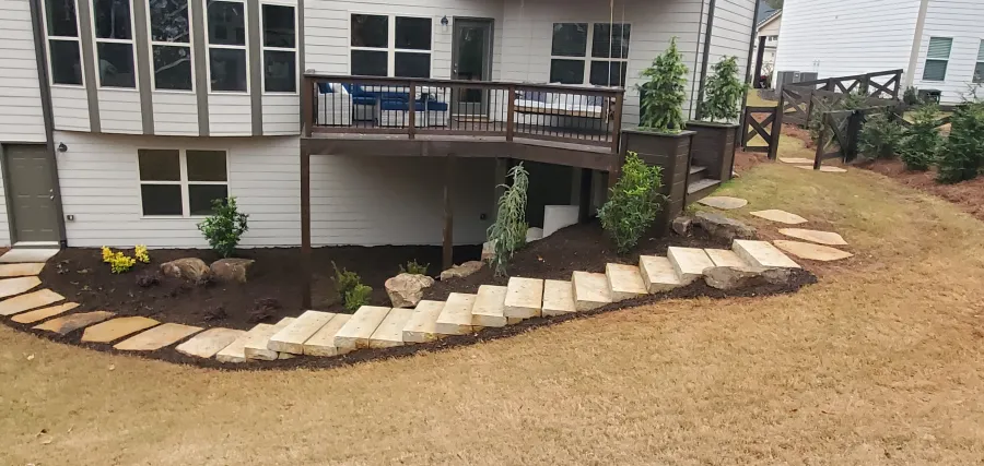a house with a deck and a small garden in the front in canton, ga