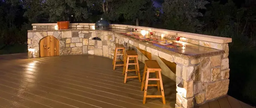 a wood deck with stools and a table with candles on it