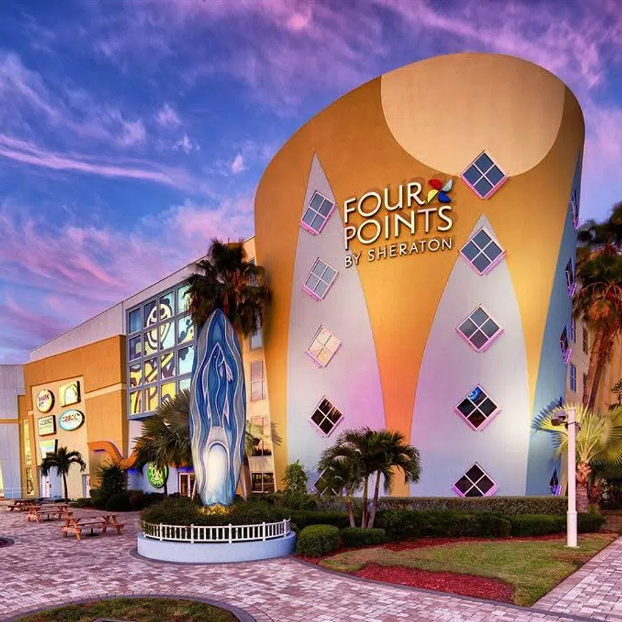 Colorful Four Points by Sheraton hotel building with unique windows and outdoor sculpture at sunset.