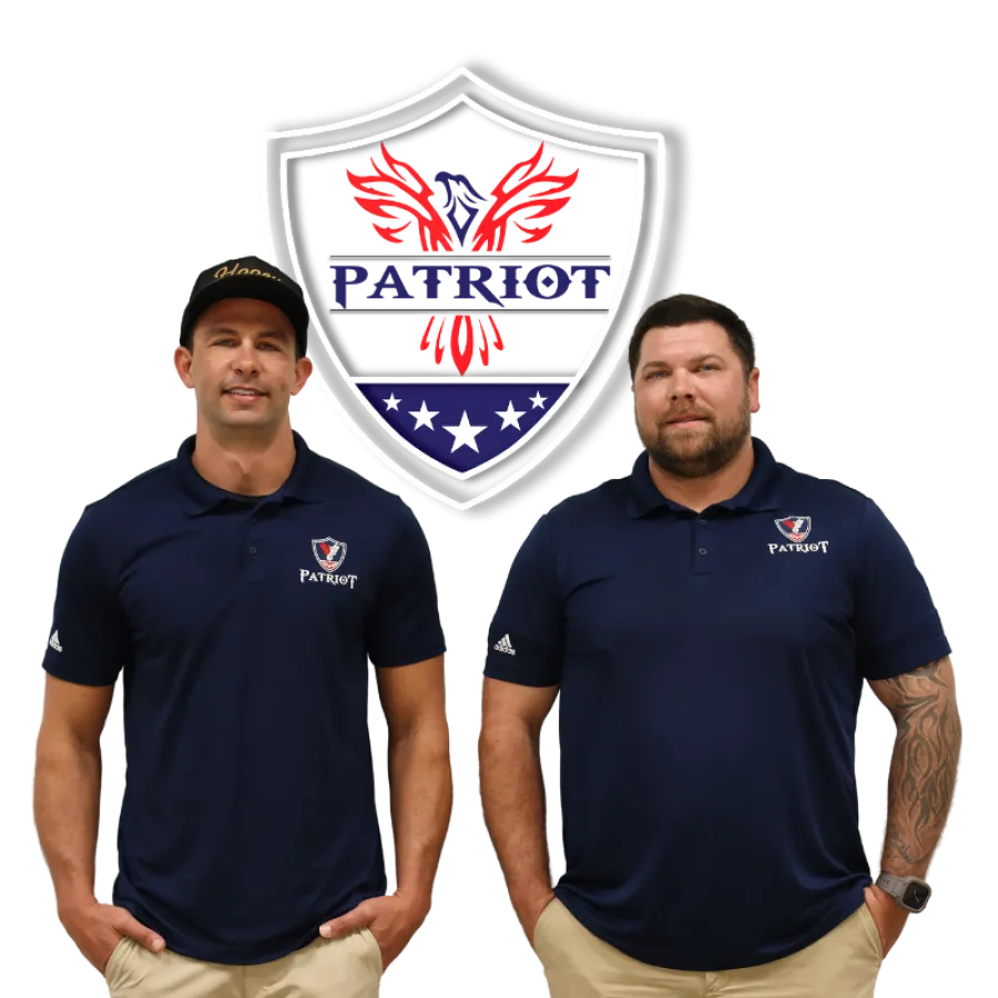 Two men in navy Patriot polo shirts stand confidently with a Patriot shield logo behind them