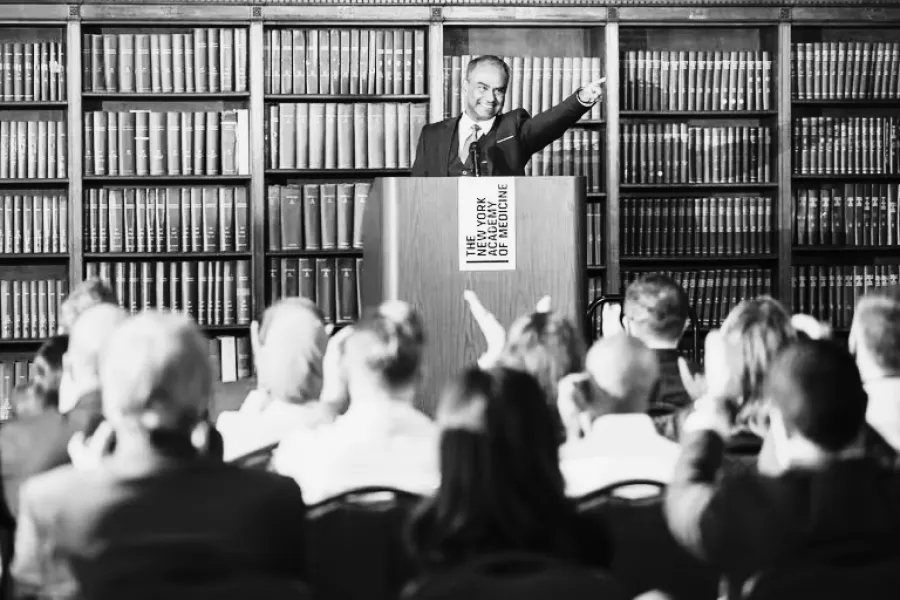 Speaker at podium in library giving a lecture to an engaged audience at the New York Academy of Medicine.