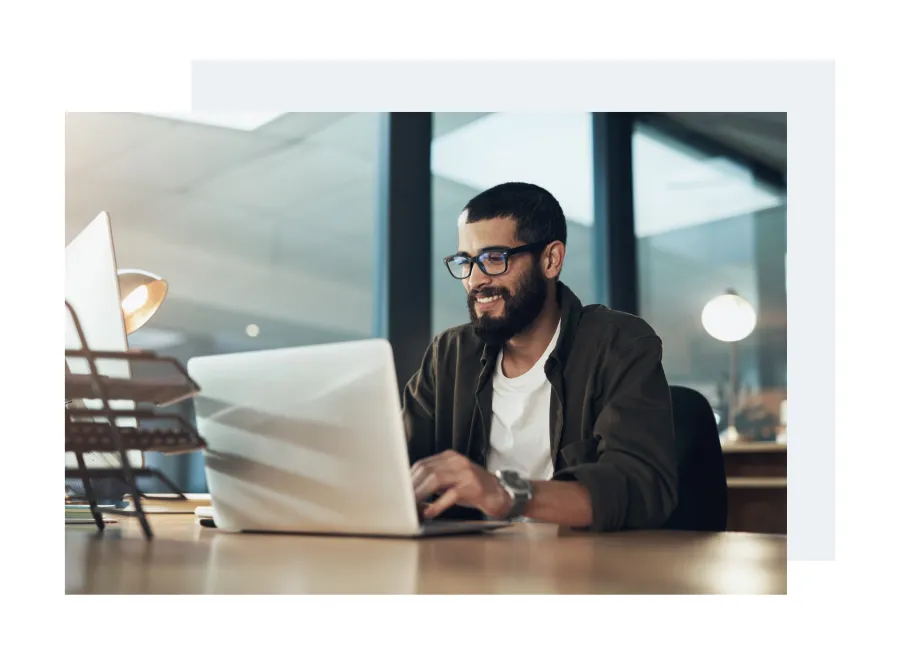 a man sitting at a desk with a laptop