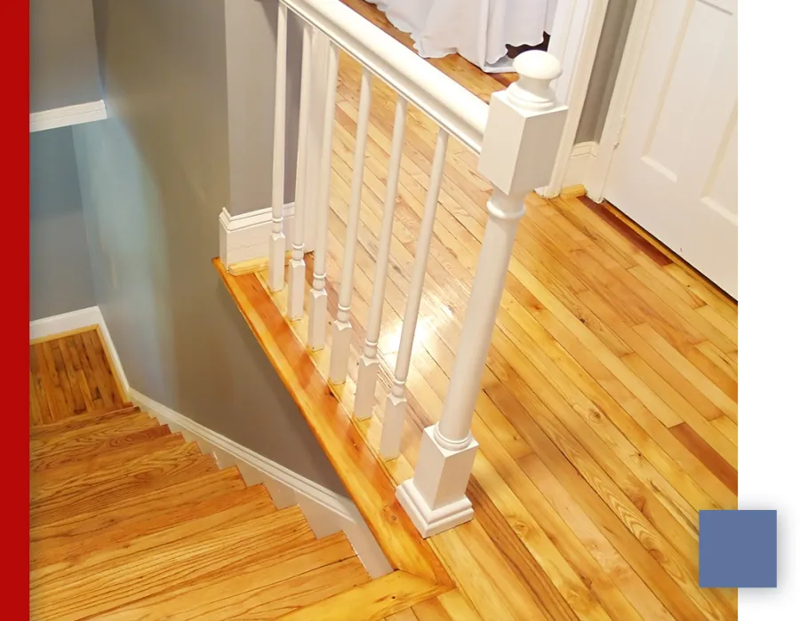 Top view of wooden staircase with white railing and light hardwood floor in a modern home interior
