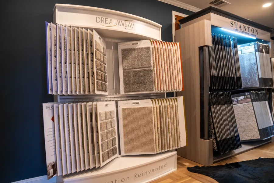 Carpet sample displays from Dreamweaver and Stanton brands in a showroom with various textures and colors.