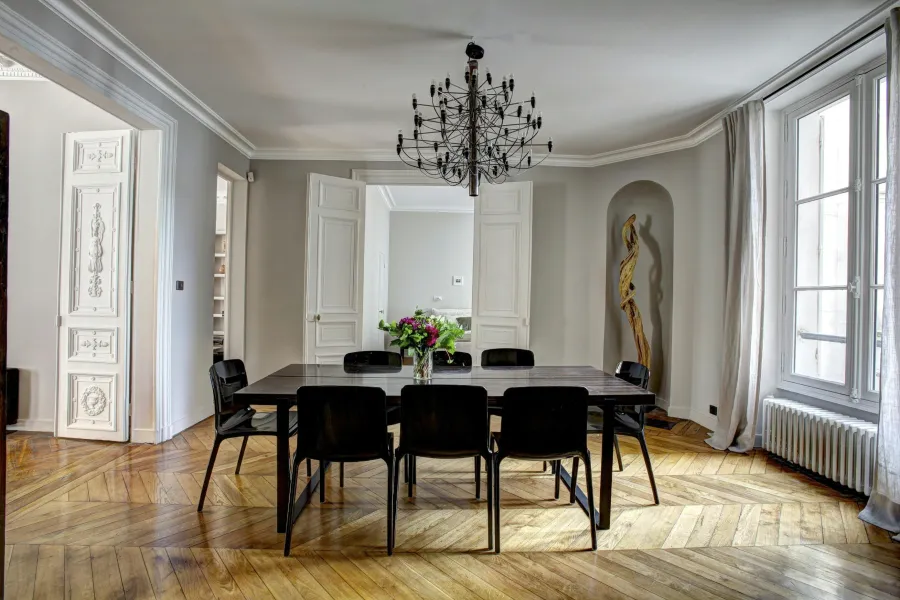 a dining room with a chandelier and chairs