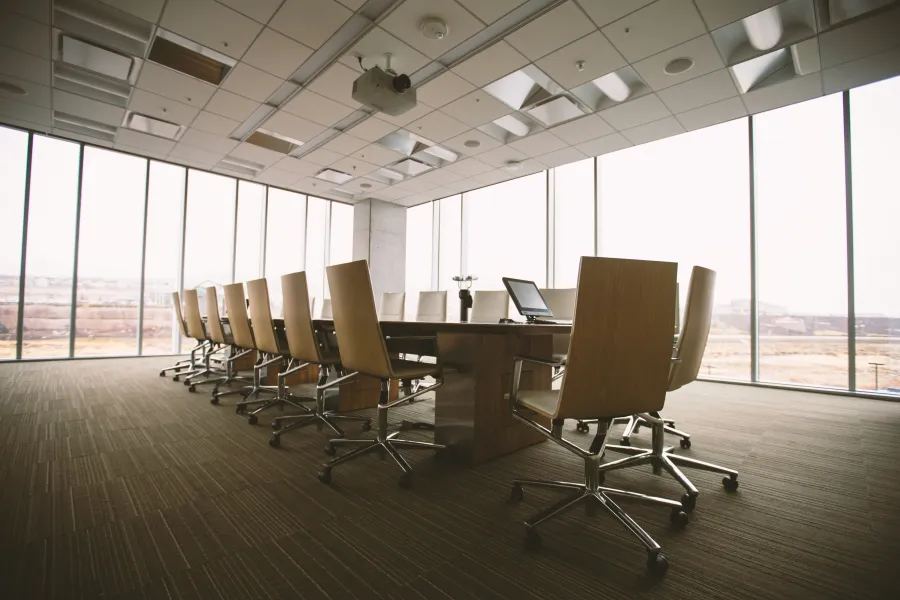 a room with a desk and chairs