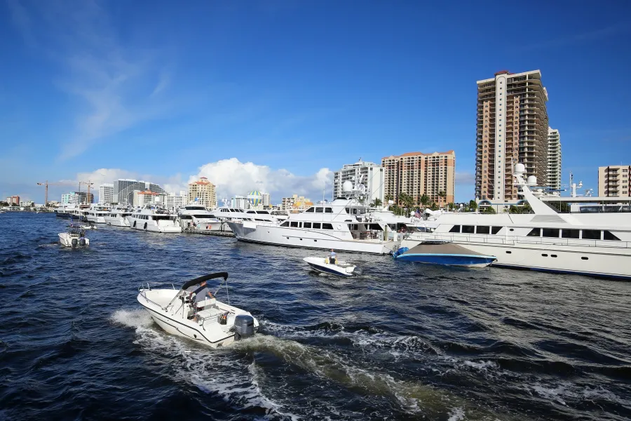 a group of boats in a body of water with buildings in the background