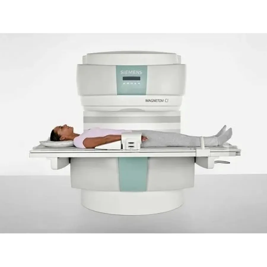 Person lying on magnetic resonance imaging (MRI) scanner bed during medical scan procedure in clean clinical setting