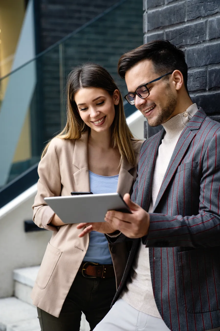 a man and a woman looking at a tablet