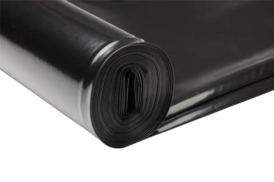 Close-up of a tightly rolled black plastic garbage bag with smooth texture on a white background
