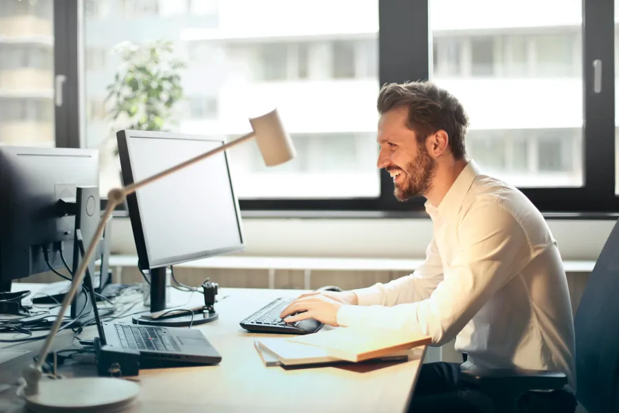 a person sitting at a desk with a computer