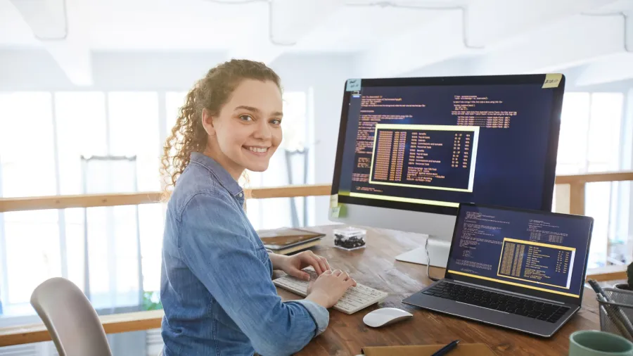 Sophi Bairley sitting at a desk with a laptop and a computer