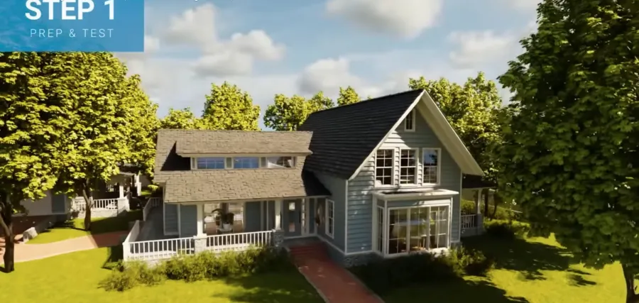 Modern blue-gray house with large windows, surrounded by green trees and a sunny sky with clouds.