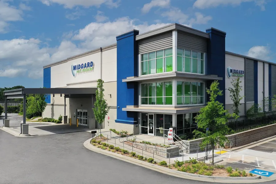 Modern Midgard Health & Fitness building with blue accents and large windows under a partly cloudy sky