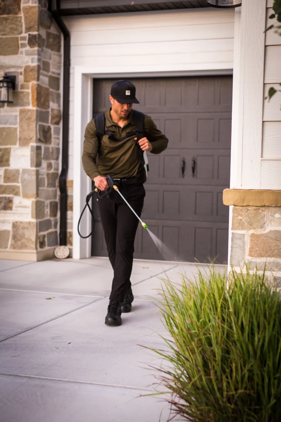 a Ridd technician spraying driveway