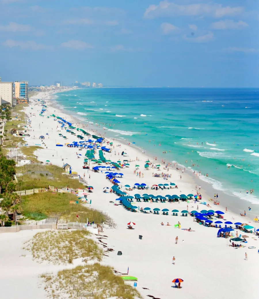 a crowded beach with blue water