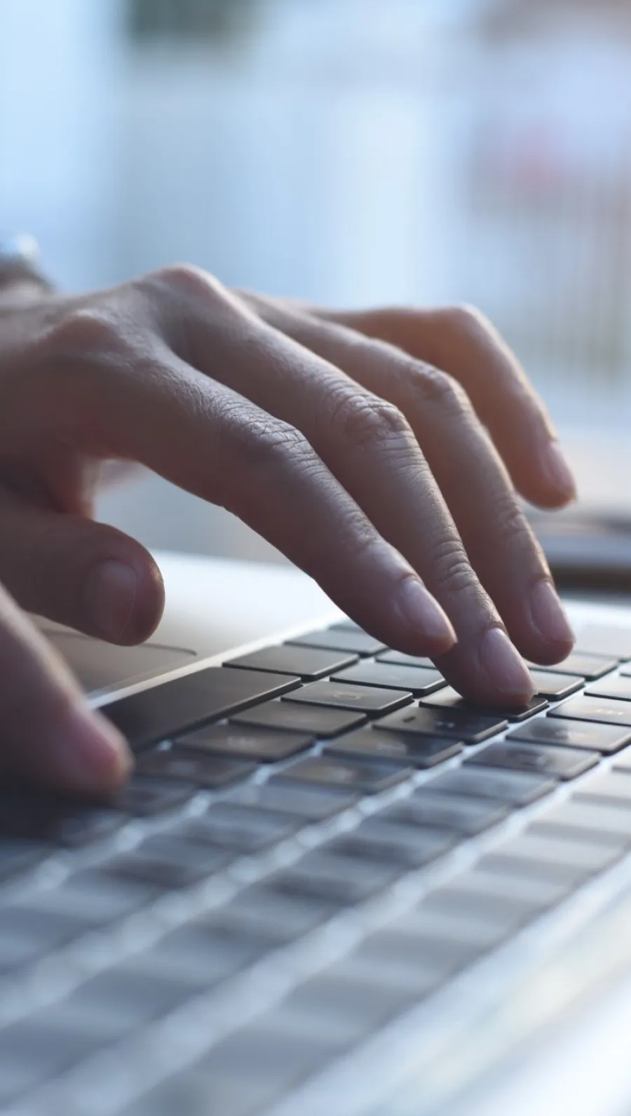 a close-up of hands typing on a keyboard