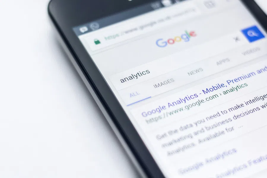 Smartphone screen displaying Google search results for analytics with visible search bar and web links.