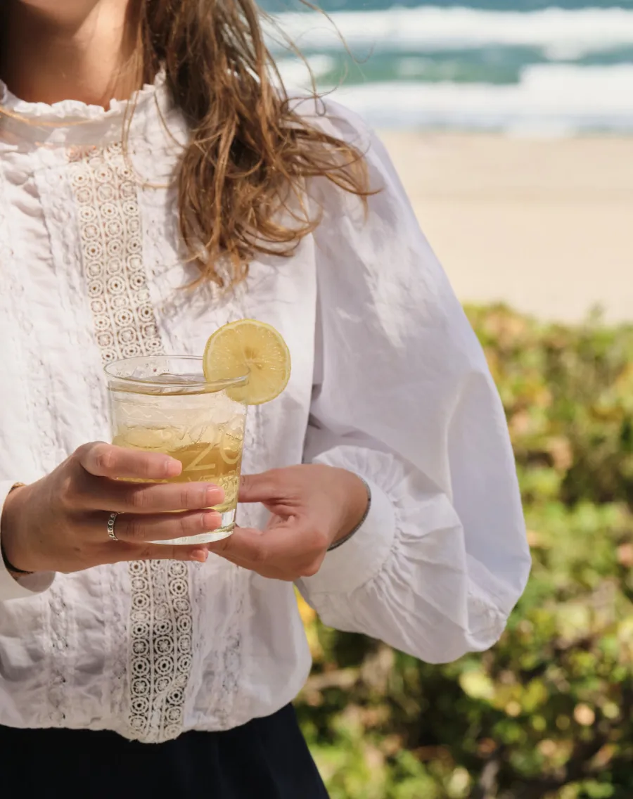 a woman holding a glass of liquid