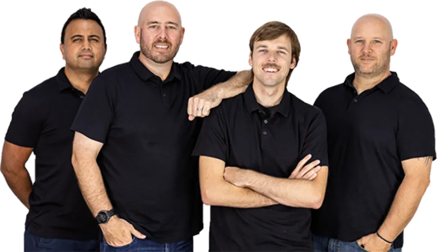 Four men wearing black polo shirts posing together against a white background with friendly expressions.