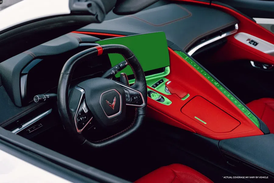 Sports car interior with black steering wheel, red leather seats, and a central touchscreen dashboard.