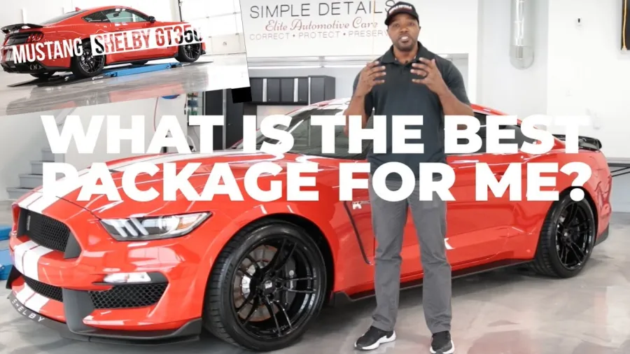 Man presenting a red Shelby GT350 Mustang with white racing stripes in a garage setting
