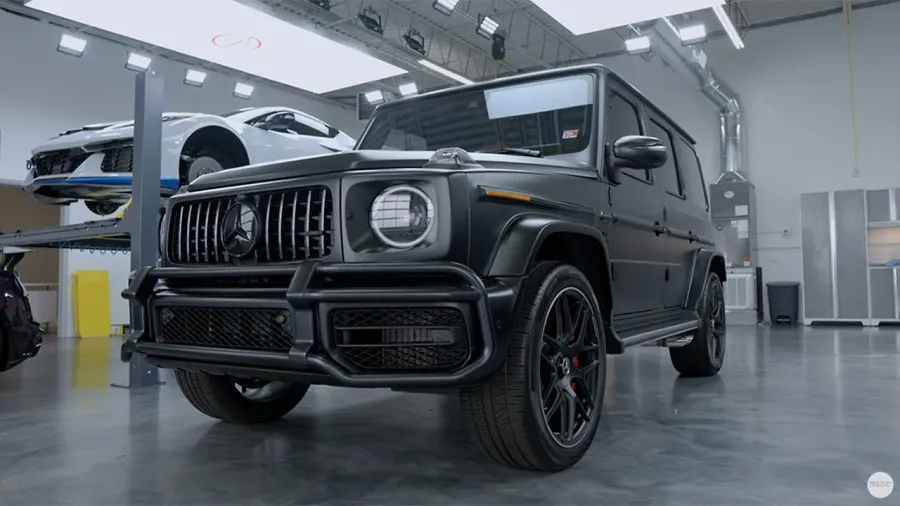 Matte black Mercedes-Benz G-Class SUV in a showroom with polished concrete floors and modern lighting.