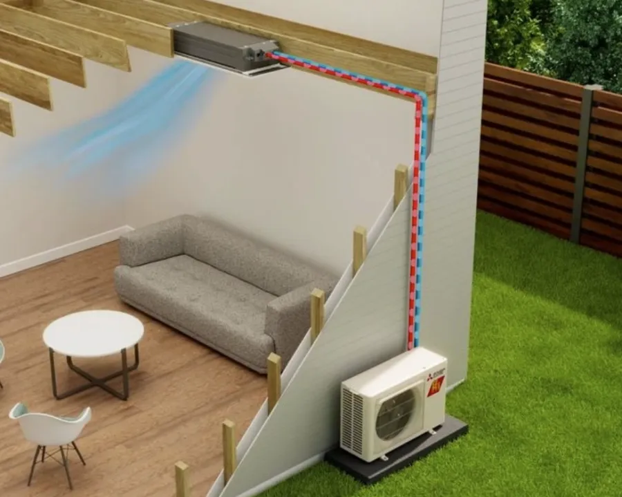 Cutaway view of a split air conditioning system cooling a living room with sofa, table, and chair.