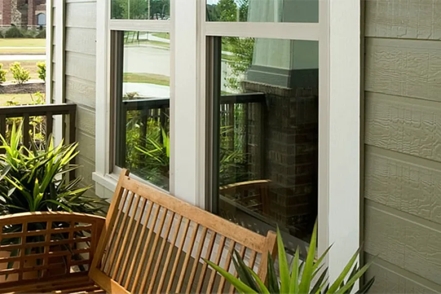 a deck with a chair and a table in front of a window